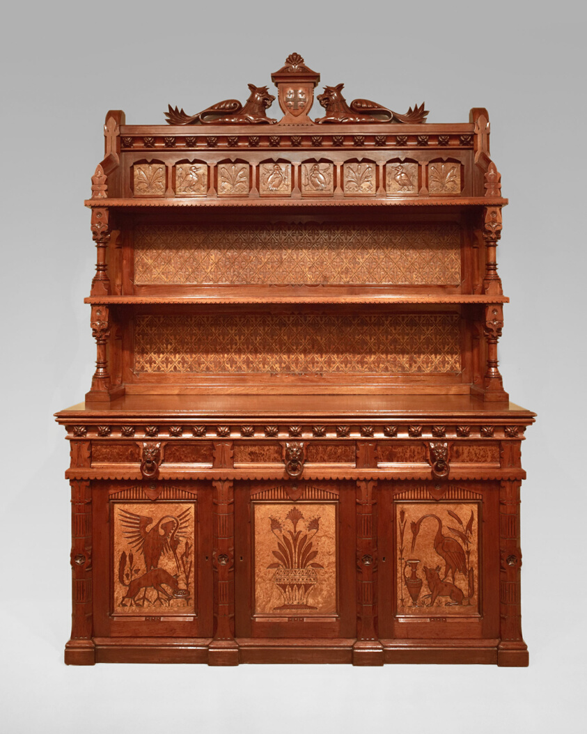 Large walnut sideboard with two shelves, animal designs on doors, gryphons at top.