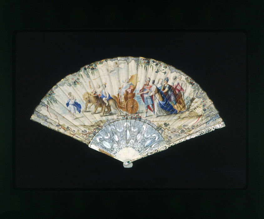 A work made of ivory guards and sticks, etched and carved; metal and mother-of-pearl insets; paper mount painted; gold leaf; metal pin with imitation gemstones.