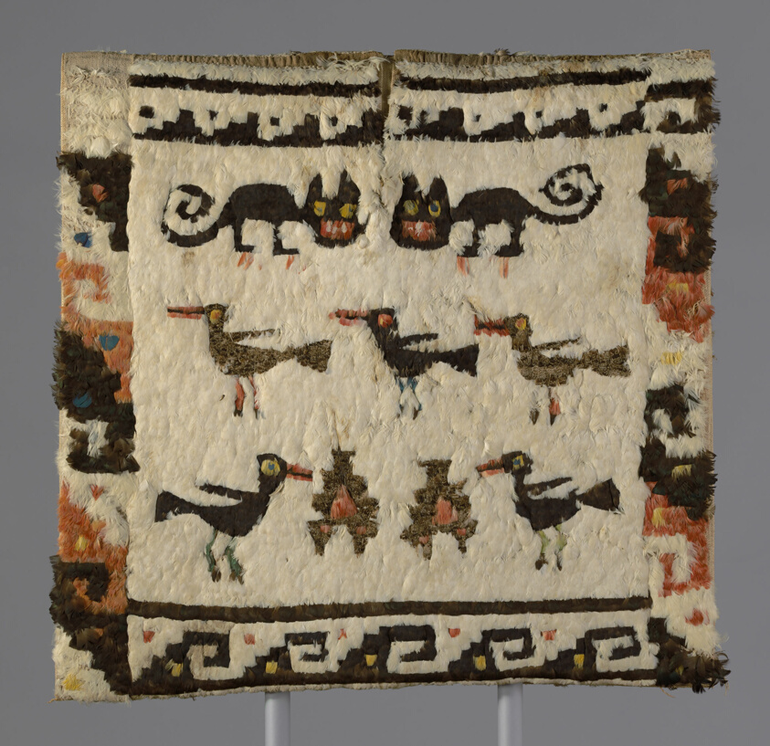 Cream-colored tunic with stylized birds, cats, and geometric border.