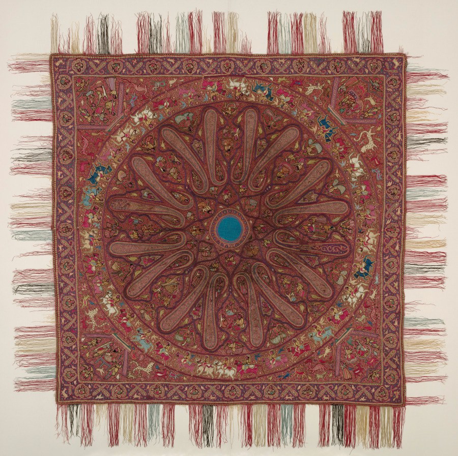 A square Kashmiri shawl covered with a dense arrangement of curved red, cream and dark blue boteh motifs.